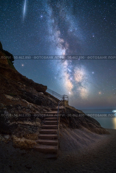 Milky Way and stairs on the beach at summer starry night. Summer in Lefkada, Greece. Beautiful landscape with sky with bright stars and milky way, meteorite, steps, sandy beach, rock, sea coast. Space. Milky Way and stairs on the beach at summer starry night. Стоковое фото, агентство Ingram Publishing / Фотобанк Лори