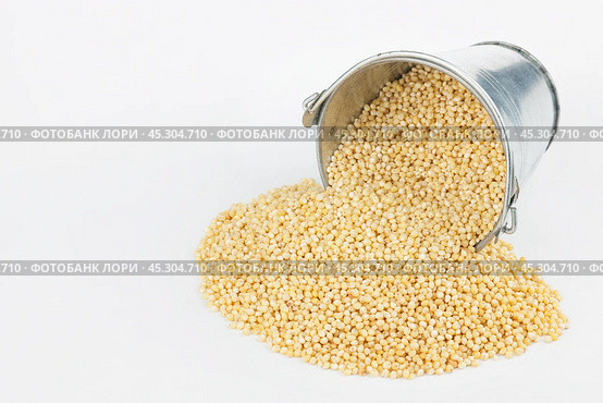 Millet grains spilling out of bucket. Стоковое фото, фотограф Александр Собко / Фотобанк Лори