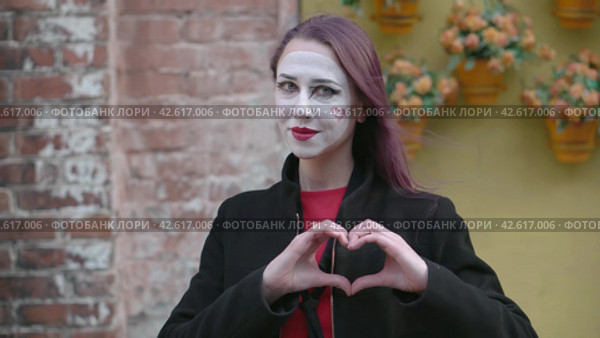 Mime young woman in a black coat making heart shape out of the hands and then blowing a kiss. Happy Valentines Day. Руками знак сердце и воздушный поцелуй. Стоковое видео, видеограф EStarodubov / Фотобанк Лори