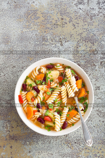Minestrone soup. Vegetable soup with fresh tomato, celery, carrot, zucchini, onion, pepper, beans and pasta. Dish of italian cuisine. Стоковое фото, агентство Ingram Publishing / Фотобанк Лори