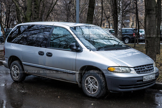 Минивэн Chrysler Voyager припаркован на улице. На кузове машины капли после дождя. Автомобиль Chrysler Caravan третьего поколения. Редакционное фото, фотограф Константин Григорьев / Фотобанк Лори