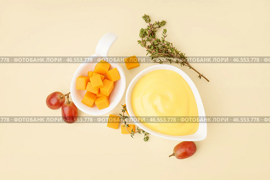Миска с вкусным соусом из чеддер-сыра, тимьяном и виноградом на бежевом фоне. Стоковое фото, фотограф Pixel_shot / Фотобанк Лори