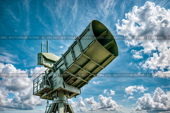 Modern air defence radar of military mobile missile launcher system of green color at blue cloudy sky background. Air defense installation outdoors. Concept of modern army industry. Copy ad text space. Стоковое AI-изображение, AI-художник Aleksandr Golubev / Фотобанк Лори