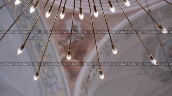 Modern chandelier illuminating ancient frescoes in a baroque church. Стоковое видео, видеограф Mikhail Davidovich / Фотобанк Лори