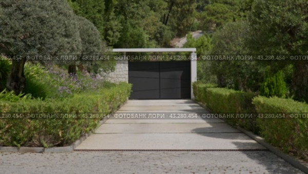 Modern home entrance with automatic gate in suburbia, daytime. Стоковое видео, видеограф PAv / Фотобанк Лори
