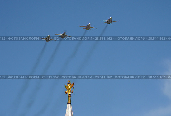 Модернизированные фронтовые бомбардировщики с крылом изменяемой стреловидности Су-24М во время парада, посвященного 73-летию Победы в Великой Отечественной войне, пролетают в небе над Красной площадью (2018 год). Редакционное фото, фотограф Free Wind / Фотобанк Лори
