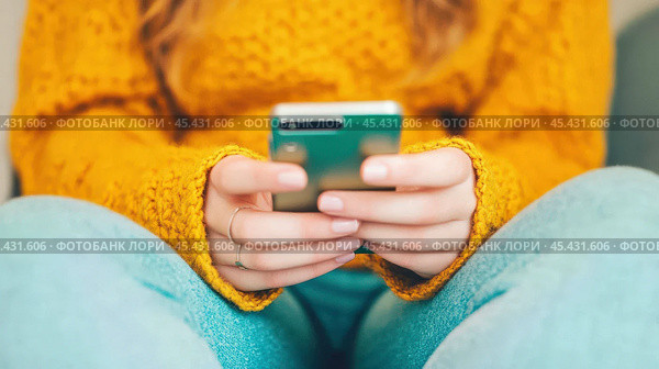 Молодая женщина использует смартфон в непринужденной атмосфере для цифровых медиа и общения. Стоковое AI-изображение, AI-художник ФотоИнтеллект / Фотобанк Лори