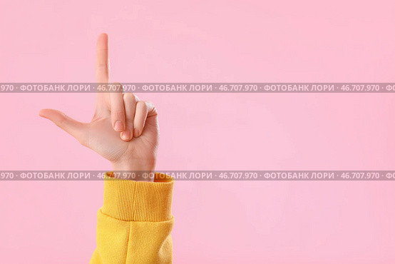 Молодая женщина показывает жест неудачника на розовом фоне. Стоковое фото, фотограф Pixel_shot / Фотобанк Лори