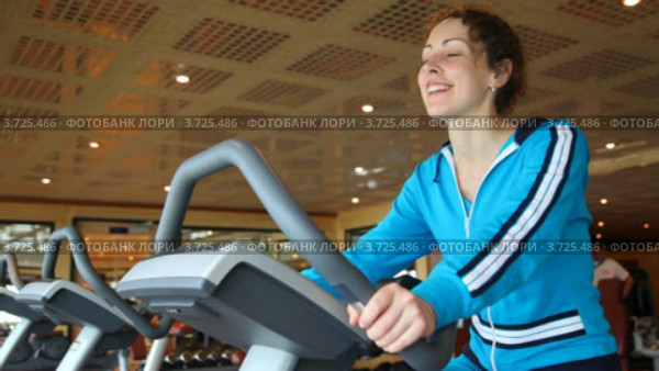 Молодая женщина занимается на велотренажере в спортивном клубе. Стоковое видео, видеограф Losevsky Pavel / Фотобанк Лори
