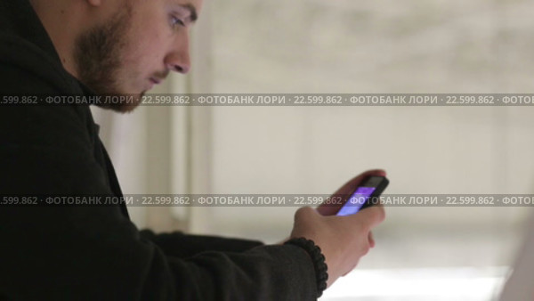 Молодой брюнет со смартфоном. Стоковое видео, видеограф Загородний Кирилл / Фотобанк Лори