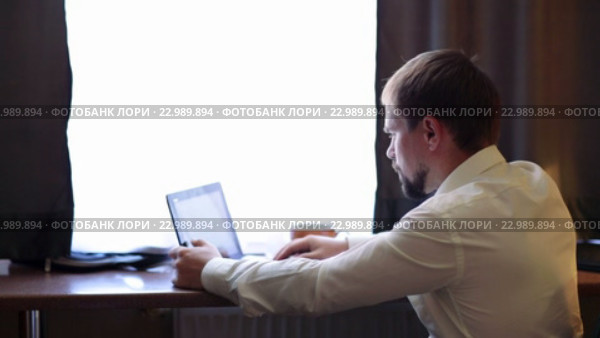 Молодой менеджер работает на компьютере в номере гостиницы. Стоковое видео, видеограф Виталий Зверев / Фотобанк Лори