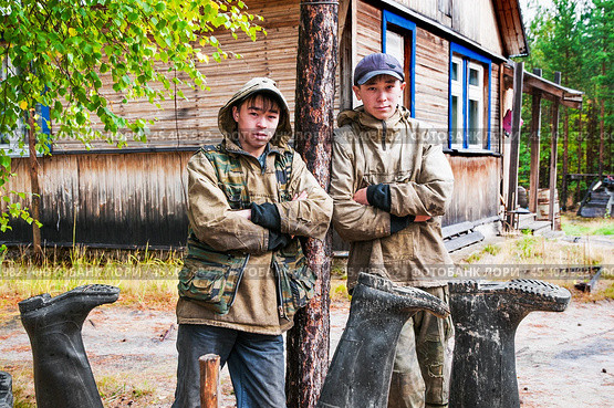 Молодые люди ( манси ), видимо братья , только что вернулись с рыбалки, и опрокинули на просушку свои сапоги ( типичный способ для здешних мест ). Их родовое имение находится в лесу ( недалеко от реки ). Они, коренные жители народов севера - манси, здесь живут годами. Основные продукты - самые, что ни на есть натуральные. Все остальное покупают раз в месяц, в городе. Сообщение с городом круглый год по реке , километров 20-25... (2011 год). Редакционное фото, фотограф Павел Просянов / Фотобанк Лори