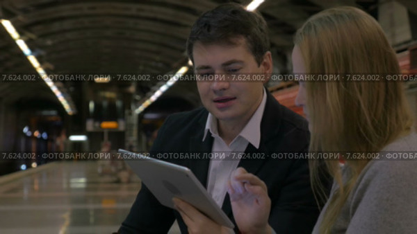 Молодые люди обсуждают что-то с планшетом в руках в метро. Стоковое видео, видеограф Данил Руденко / Фотобанк Лори