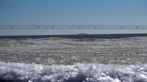 Морские волны со снежной ледяной массой набегают на берег, покрытый мелкими льдинами. Лед со снегом плывет по морским волнам у берега. Стоковое видео, видеограф Александр Кротков / Фотобанк Лори