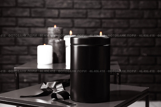 Mortuary urn with ribbon on table in room. Стоковое фото, фотограф Pixel_shot / Фотобанк Лори