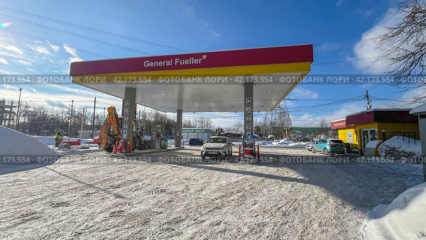 Moscow 08 February 2024, A taxi car at a gas station in the winter is refueled with gasoline. Редакционное фото, фотограф Скрипачев Антон / Фотобанк Лори