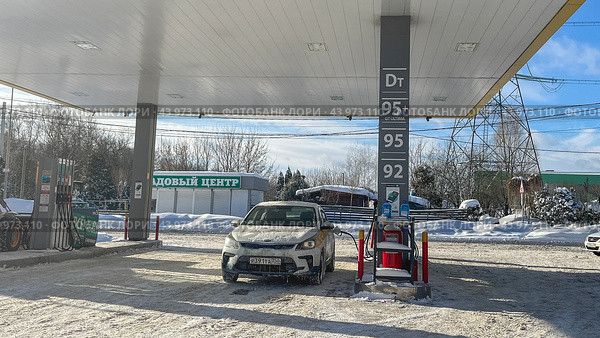 Moscow 08 February 2024, A taxi car at a gas station in the winter is refueled with gasoline. Редакционное фото, фотограф Скрипачев Антон / Фотобанк Лори