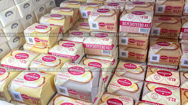 Moscow December 04, 2024, Butter in packaging on a store counter. Concept of increasing prices for butter. Refrigerator in a grocery store with briquettes of natural butter. Редакционное фото, фотограф Скрипачев Антон / Фотобанк Лори