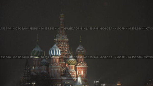 Moscow January 08 2021, Focus is majestic Cathedral of Blessed Vasily, whose multi colored domes sparkle light of festive illumination. Snowflakes are quietly spinning in air, adding scene of magic. Редакционное видео, видеограф Скрипачев Антон / Фотобанк Лори