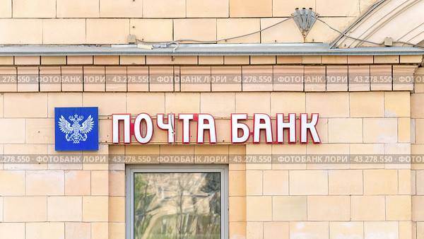 Moscow May 05 2024. Pochta Bank. Sign on building, passers-by walking by blurred in foreground. Редакционное фото, фотограф Скрипачев Антон / Фотобанк Лори