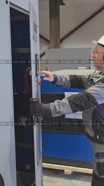 Moscow, Russia, July 3, 2025. A process engineer opens the compressor panel and starts up the equipment. Редакционное видео, видеограф Юрий Поздников / Фотобанк Лори