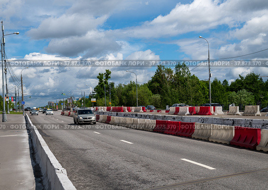 Moscow, Russia - June 05. 2022. Water-filled barriers stand along the road during repairs. Редакционное фото, фотограф Володина Ольга / Фотобанк Лори