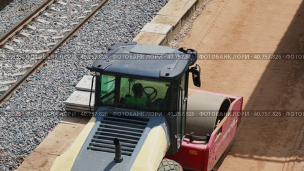 Moscow, Russia. June 30, 2023. A construction roller tamping down sand at a construction site. Station construction. Редакционное видео, видеограф Юрий Поздников / Фотобанк Лори