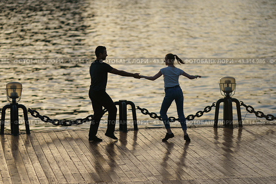 Moscow, Russia - May18, 2021: Cute heterosexual couple of man and woman dances in public park. Beautiful pair. Leisure concept. Healthy lifestyle theme. Deep dive in dance. Редакционное фото, фотограф YuryKara / Фотобанк Лори