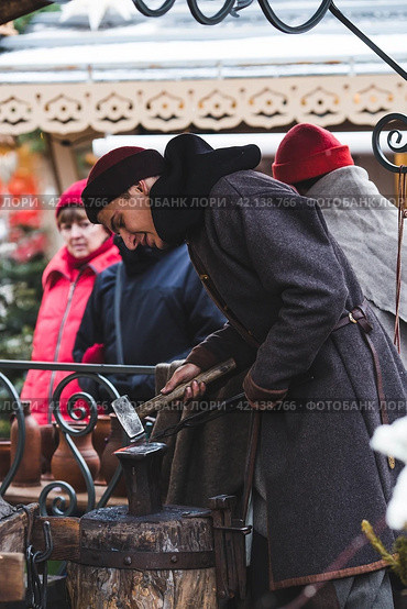 Moscow seasons. A traditional craft. Blacksmith's work with metal. Russian traditions. Hammer and anvil. Moscow. Russia (2023 год). Редакционное фото, фотограф Photojuli / Фотобанк Лори