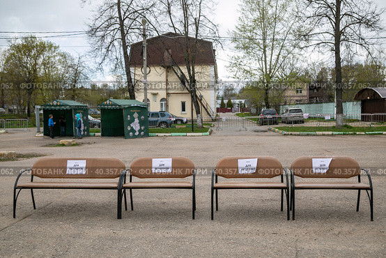 Московская область, поселок Тучково. 9 мая в День Победы четыре банкетки с белыми табличками "Для ветеранов" стоят на улице на территории Тучковского центра культуры и искусств (2022 год). Редакционное фото, фотограф Наталья Николаева / Фотобанк Лори