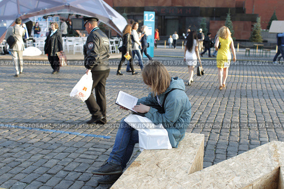 Московский фестиваль "Книги России" 2015 на Красной площади, молодой человек зачитался книгой. Редакционное фото, фотограф Дмитрий Неумоин / Фотобанк Лори