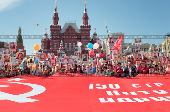 Москва, люди несут большой красный флаг на Красной площади 9 мая 2018 года. Редакционное фото, фотограф Дмитрий Неумоин / Фотобанк Лори