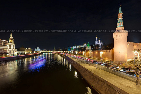Москва, Россия. Вечерний вид на Москву-реку, Кремлёвскую набережную и башни Московского Кремля. Исторический центр Москвы. Размытый свет от плывущего теплохода на длинной выдержке. Стоковое фото, фотограф Андрей Степанов / Фотобанк Лори