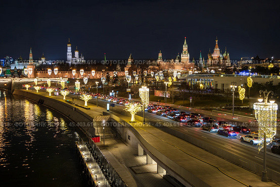 Москва, Россия. Вид сверху на Москворецкую набережную. На проезжей части автомобильная пробка. Множество автомобилей в дорожном заторе. Вдали Московский Кремль. Красивое уличное освещение и новогодние гирлянды на фонарях. Стоковое фото, фотограф Андрей Степанов / Фотобанк Лори