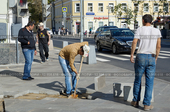 Москва, улица Большая Ордынка. Рабочие укладывают тротуарную плитку (2015 год). Редакционное фото, фотограф Елена Коромыслова / Фотобанк Лори