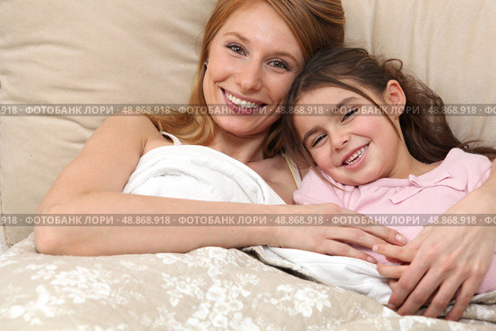 Mother and daughter in bed together. Стоковое фото, агентство Ingram Publishing / Фотобанк Лори