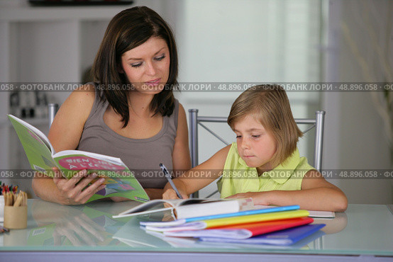 Mother helping daughter with schoolwork. Стоковое фото, агентство Ingram Publishing / Фотобанк Лори