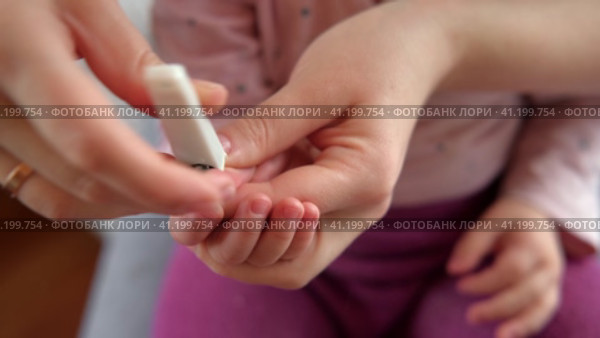 Mother use Nail Trimmer with baby hand. Mom cutting tiny fingernails. Baby care concept. How to successfully clip your baby’s nails. Closeup. Newborn hygiene. Clipping Child's Nails. Front view. 4K. Стоковое видео, видеограф Марина Демидюк / Фотобанк Лори