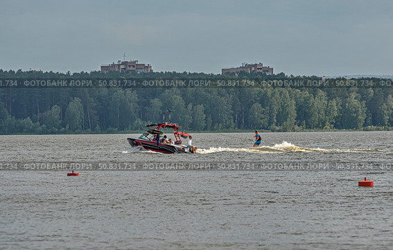 Моторная лодка мчится по воде с человеком на водных лыжах. город Железногорск, Красноярский край, Редакционное фото, фотограф Анатолий Володин / Фотобанк Лори
