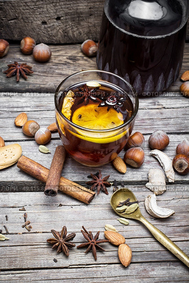 Mulled wine and spices. glass of mulled wine with almonds,cinnamon and anise on background of carafe of wine. Стоковое фото, агентство Ingram Publishing / Фотобанк Лори