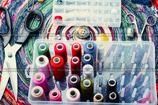 Multicolor threads, needles, buttons and seamstress instrument. Sewing accessories. A set of accessories for needlework. Стоковое фото, агентство Ingram Publishing / Фотобанк Лори