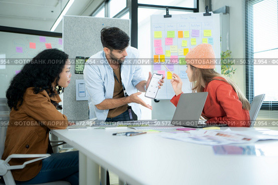 Multiethnic young business people working together in modern office, Collaborate to designing an application for use on the internet network. Стоковое фото, агентство Ingram Publishing / Фотобанк Лори