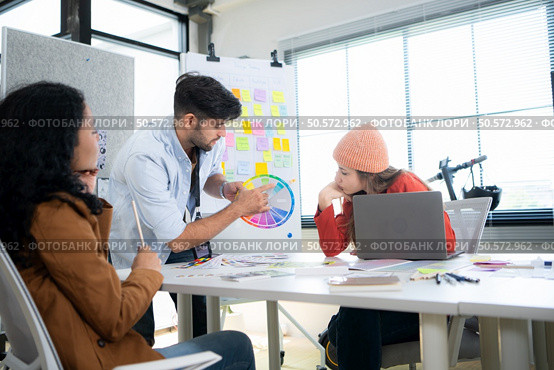 Multiethnic young business people working together in modern office, Collaborate to designing an application for use on the internet network. Стоковое фото, агентство Ingram Publishing / Фотобанк Лори
