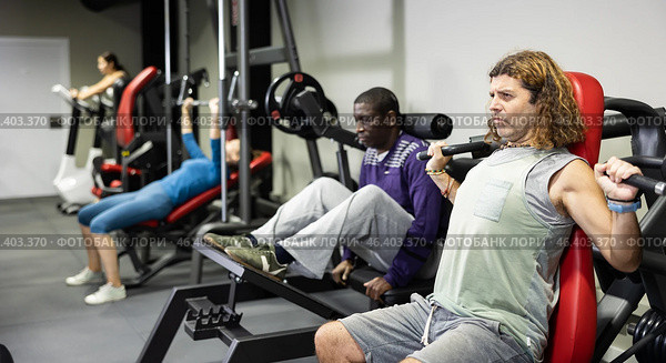 Muscular sports bodybuilder in gym is engaged in simulators. Стоковое фото, фотограф Яков Филимонов / Фотобанк Лори