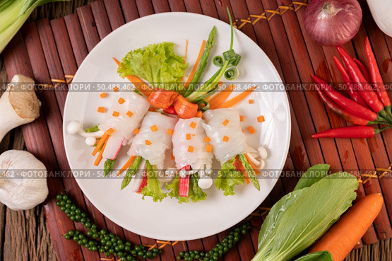 Mushrooms, carrots, asparagus, and lettuce tied with noodles. Стоковое фото, агентство Ingram Publishing / Фотобанк Лори