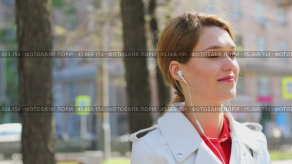 Music is always with me. Young beautiful woman listening to a song sitting on a bench in a summer park. Стоковое видео, видеограф Андрей Аркуша / Фотобанк Лори