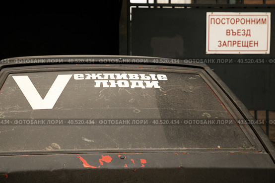 Надпись "Vежливые люди" на заднем стекле автомобиля, припаркованного под табличкой "Посторонним въезд воспрещен" Стоковое фото, фотограф Наталья Николаева / Фотобанк Лори