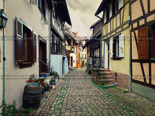 Narrow streets of the old Eguisheim village with half-timbered medieval houses along the famous wine route in Alsace, France. Стоковое фото, агентство Ingram Publishing / Фотобанк Лори