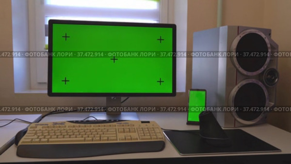 Настольный компьютер и смартфон на письменном столе в домашнем интерьере с зеленым экраном. Стоковое видео, видеограф Sergei Gorin / Фотобанк Лори