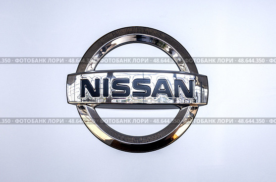 Nissan logo at the wall of car dealer's building. Nissan Motor Company Ltd is a multinational car manufacturer. Редакционное фото, фотограф FotograFF / Фотобанк Лори